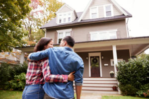 rear view of loving couple walking towards house